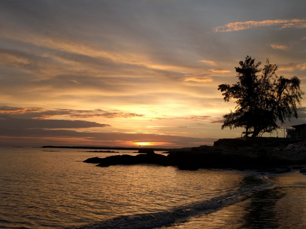 Orange sky at sunrise over the coastline in Gibara, Cuba