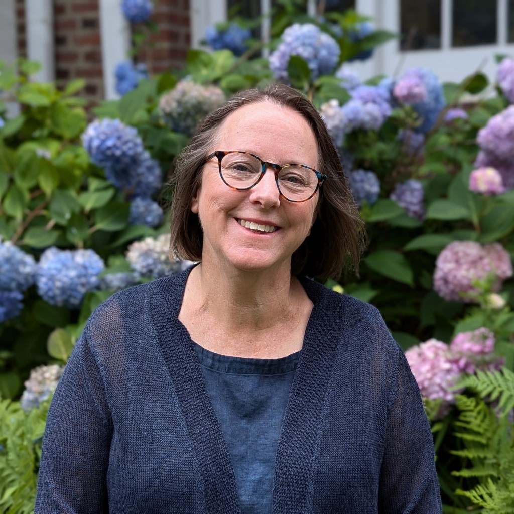 Robin standing in front of blue and pink hydrangeas